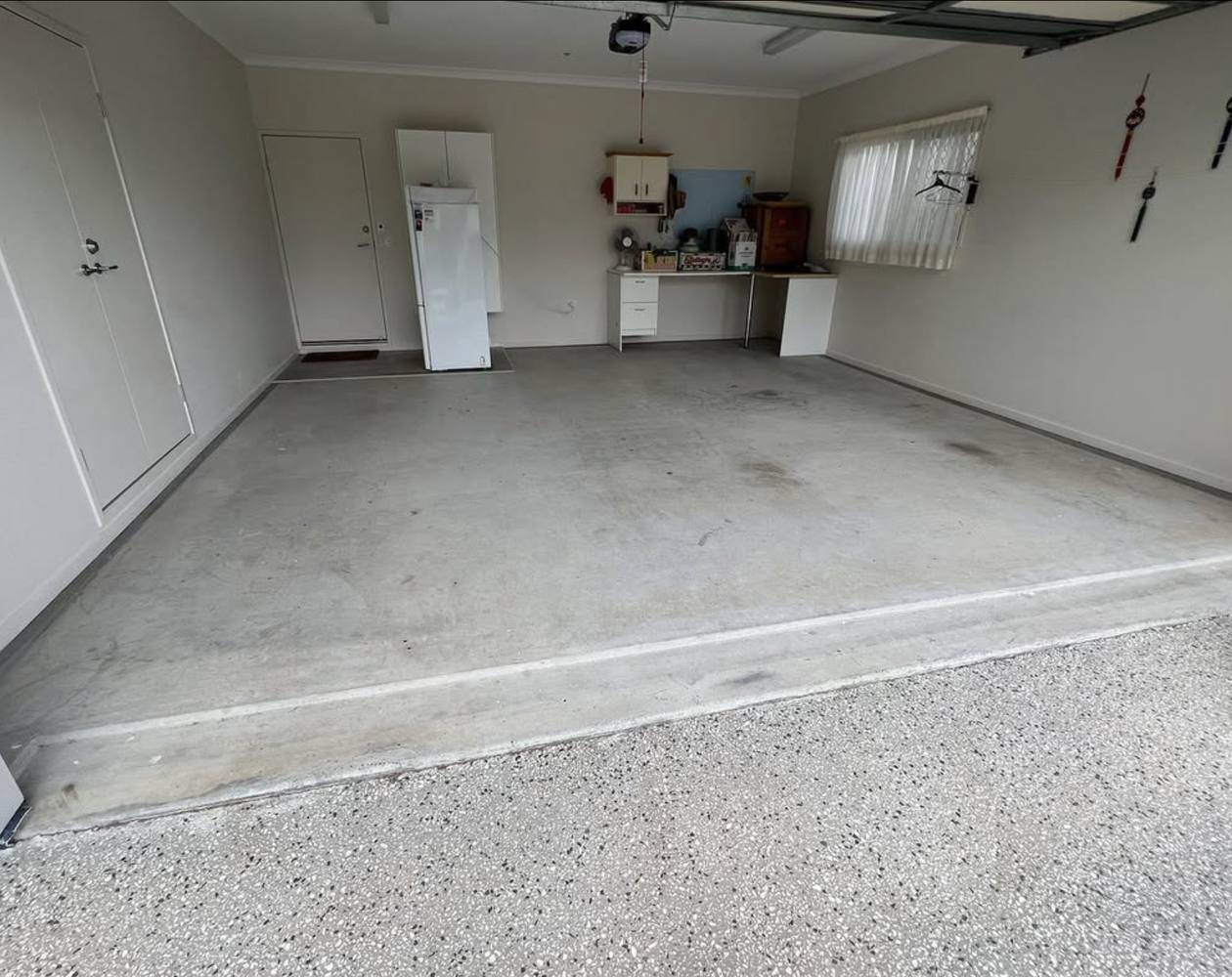 A home garage before, bare stained concrete slab